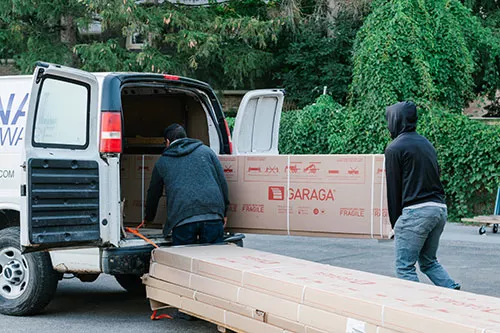 Technicians loading Garaga garage doors into the service truck